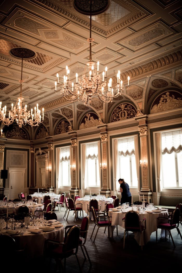 Luxurious dining room featuring classical chandeliers and ornate ceiling.